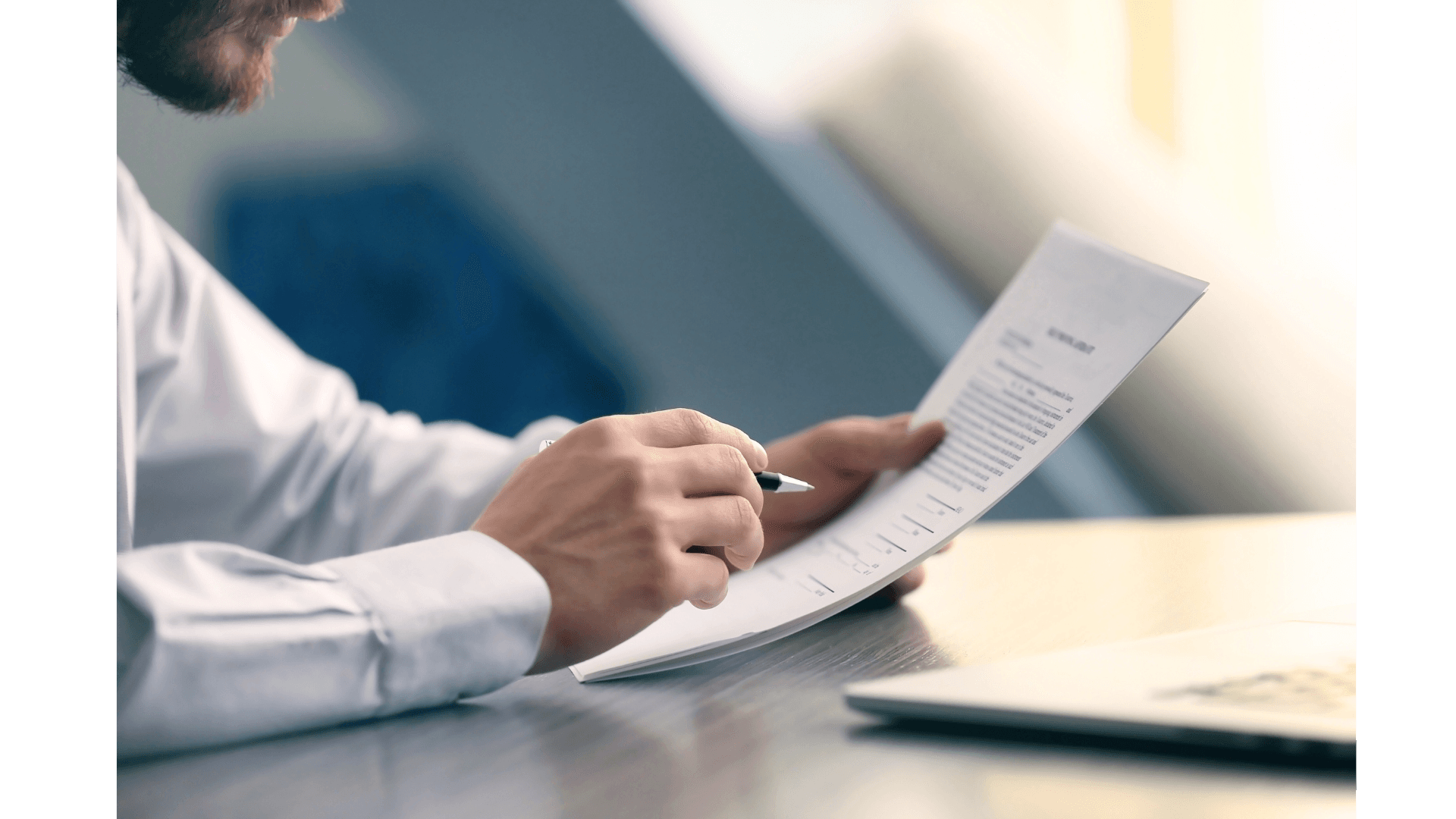 person reading papers while holding a pen